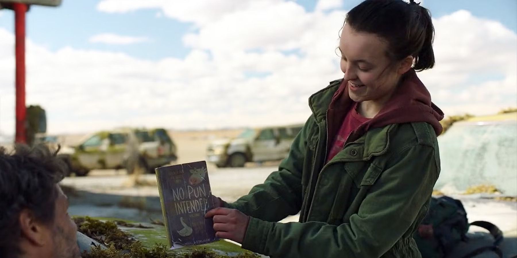 Ellie holding her book of puns and smiling in The Last of Us.