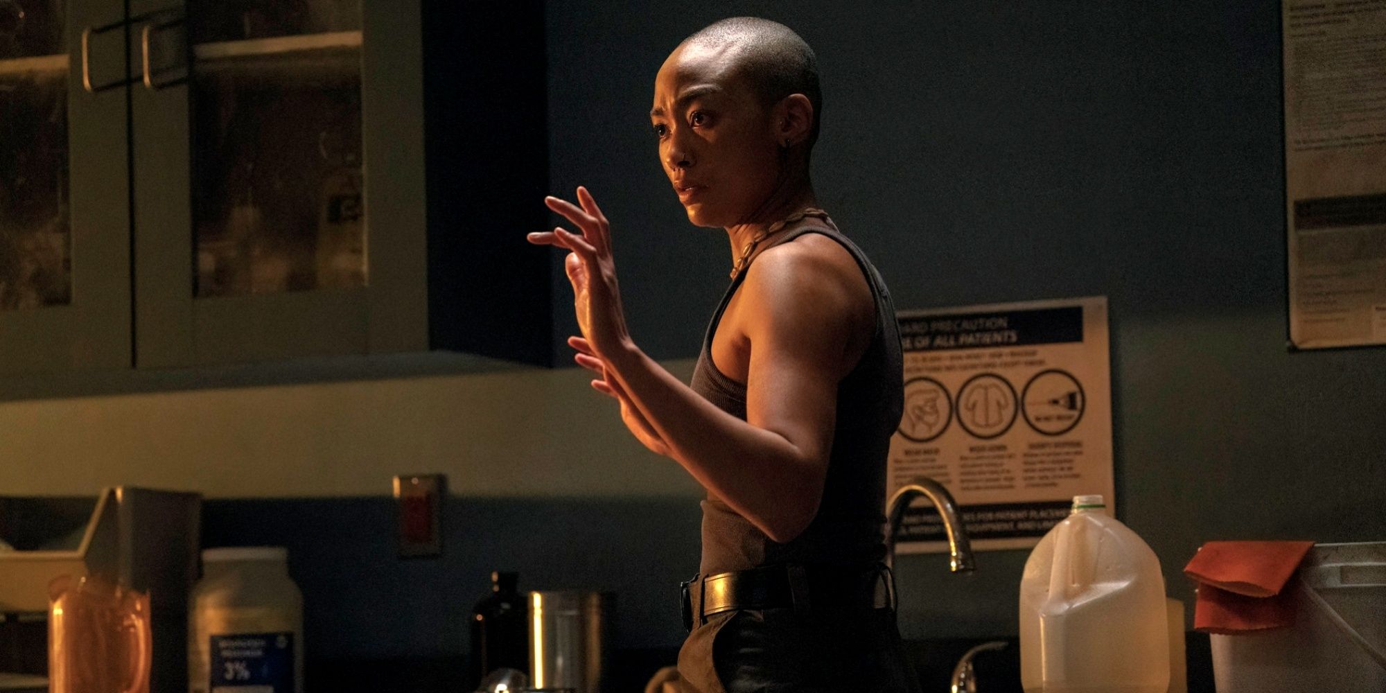 Tati Gabrielle as Nora with her hands up as Ellie holds her at gunpoint in The Last of Us Season 2