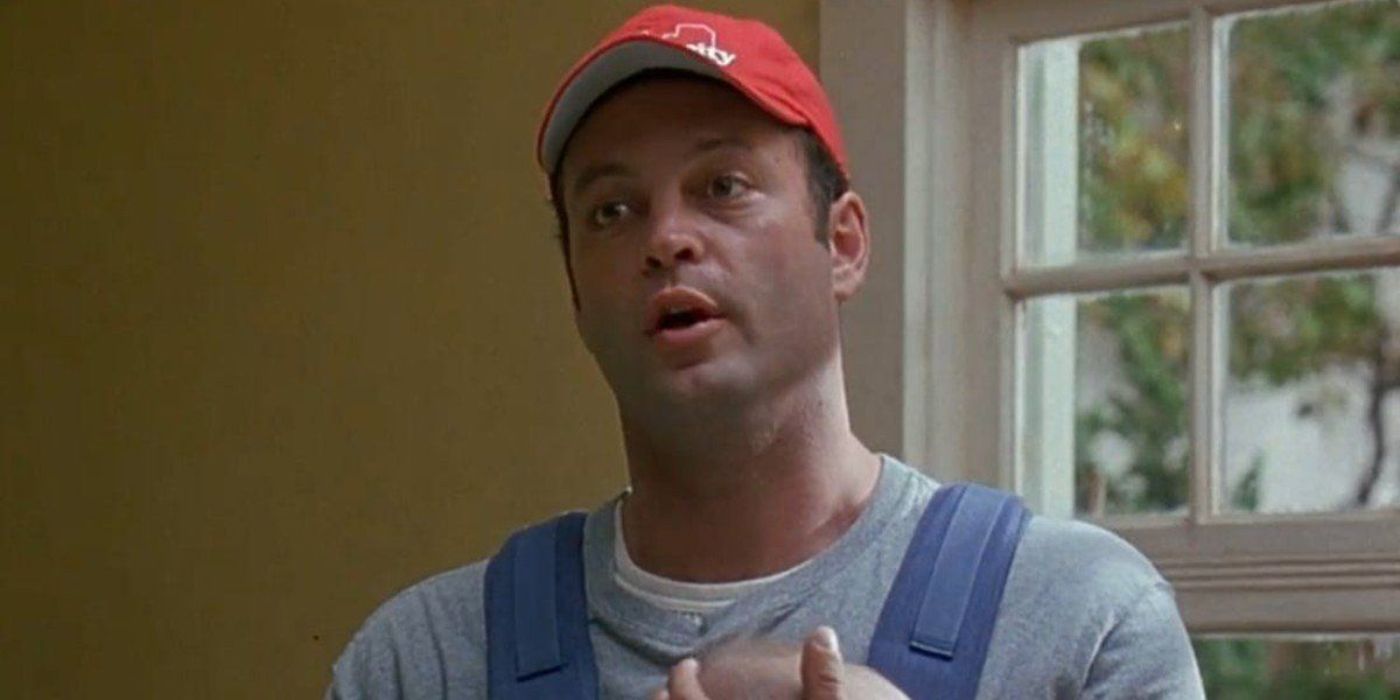 Vince Vaughn wearing a red cap and carrying a baby in a back carrier in Old School.