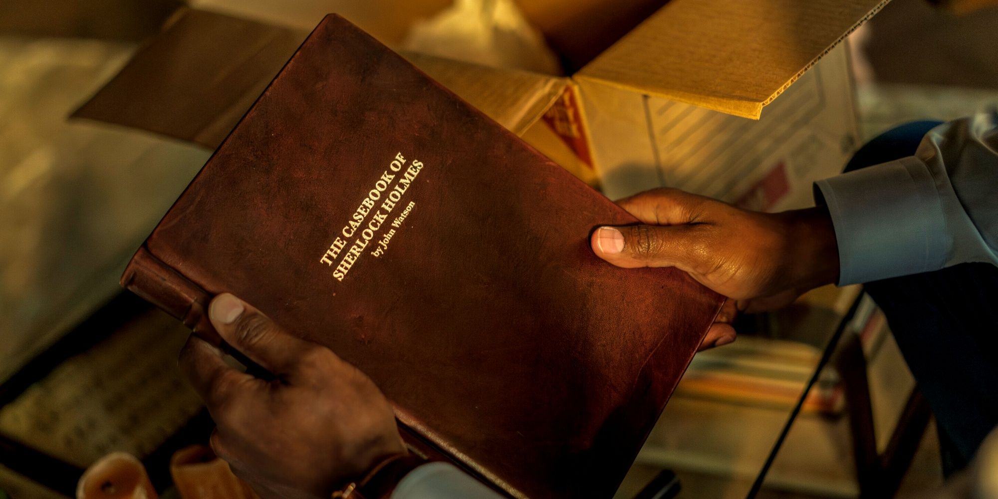 The Casebook of Sherlock Holmes By John Watson being held in John Watson's hands in the CBS series Watson