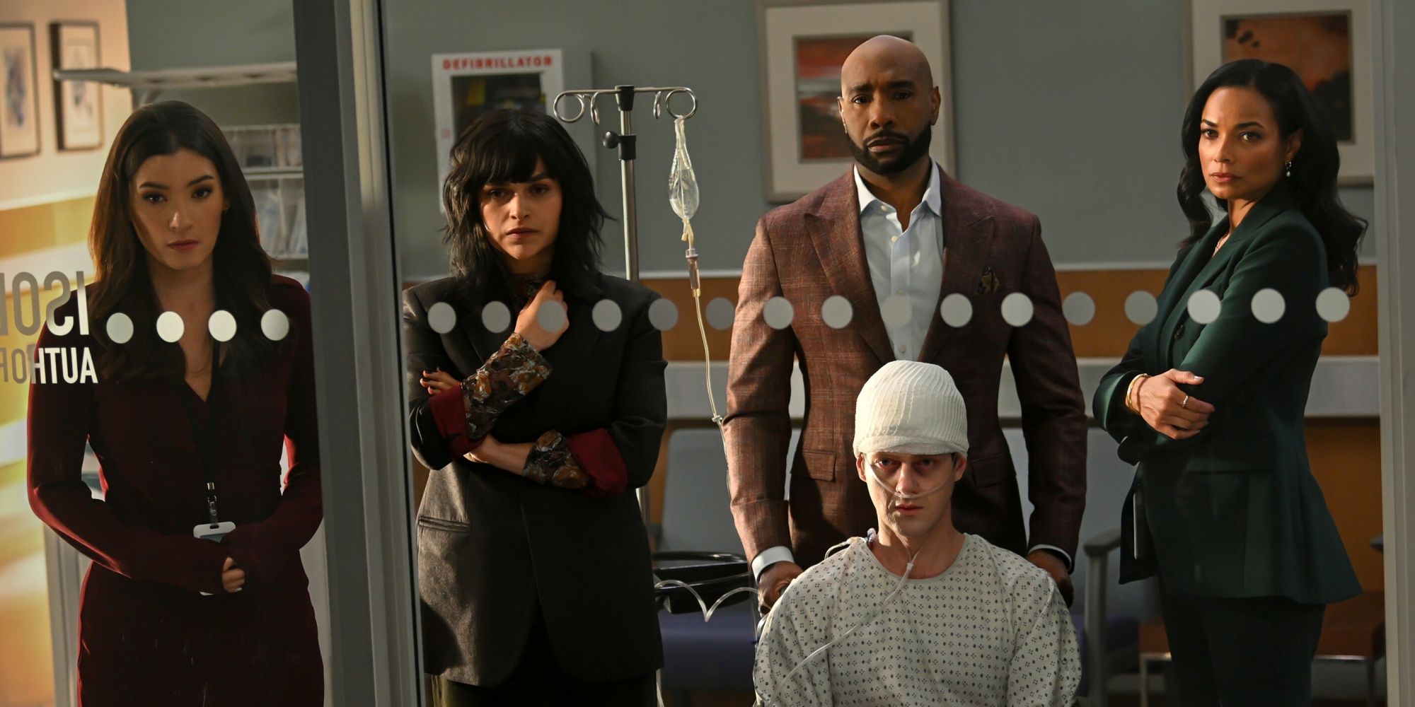 Morris Chestnut como John Watson com Peter Mark Kendall em uma cadeira de rodas ao lado de sua equipe em Watson