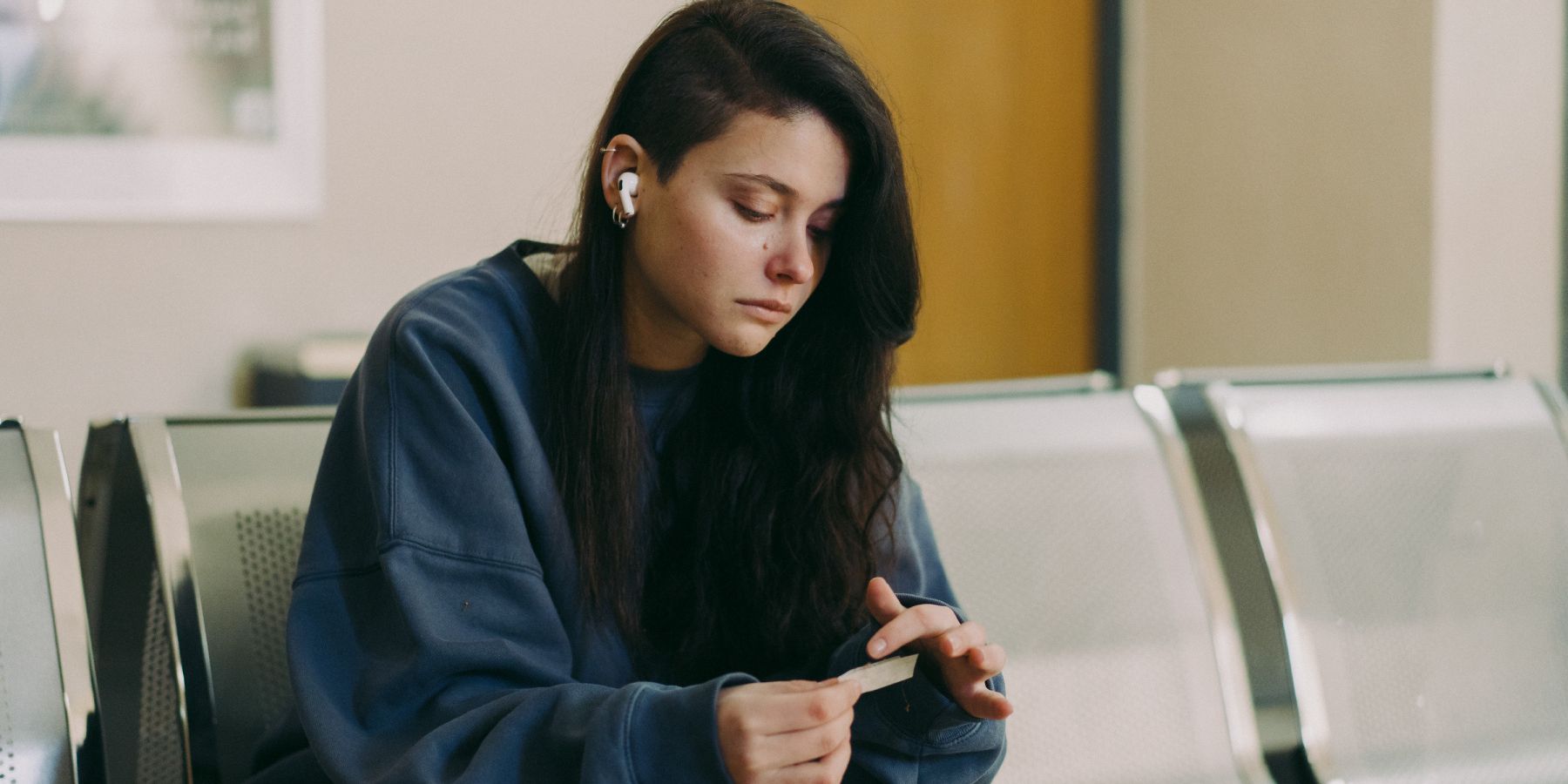 Nicole Wallace as Alma in Raising Voices sitting on a couch looking down.