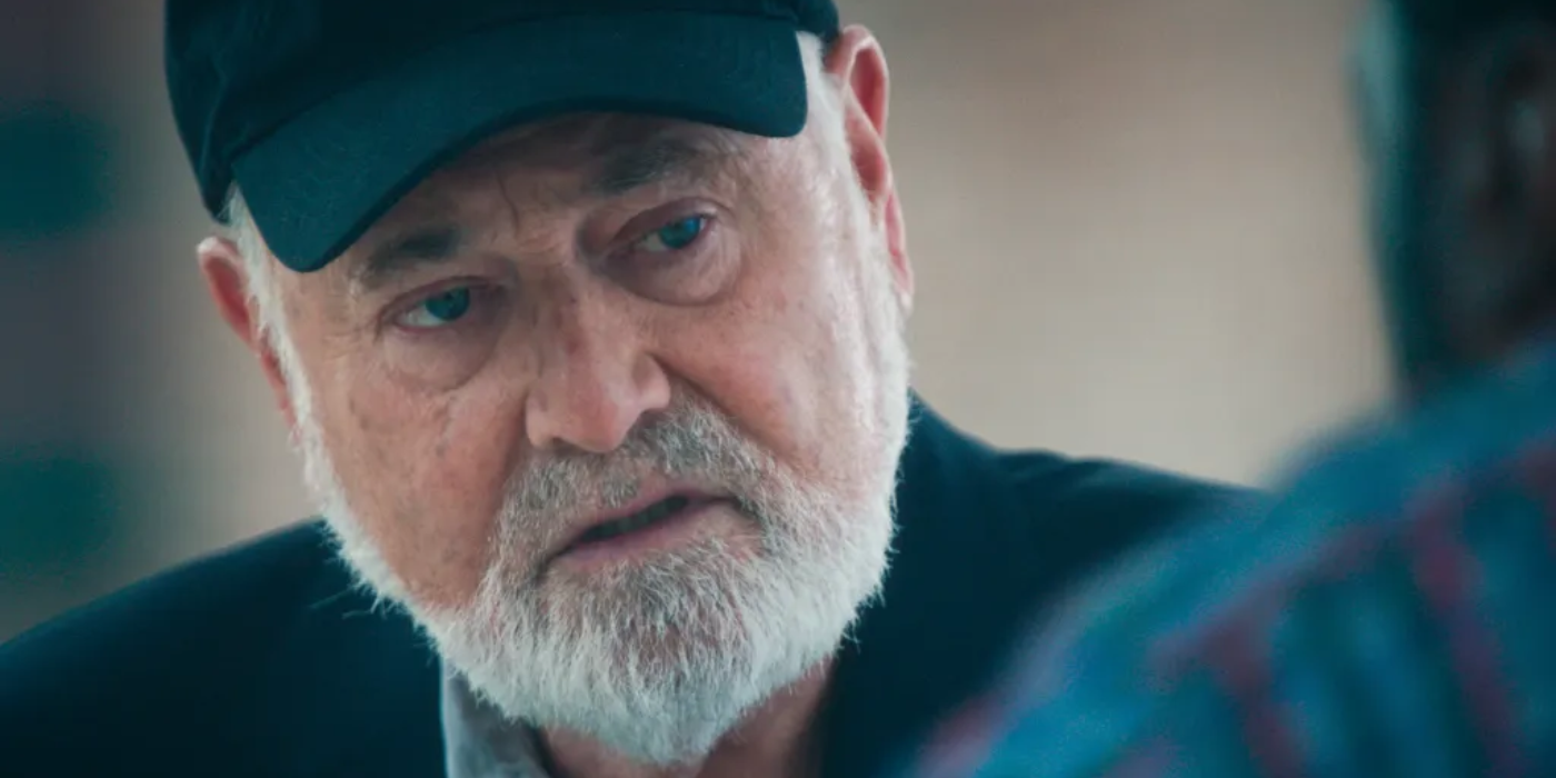 Rob Reiner wearing a baseball cap and talking to someone in The Bear.