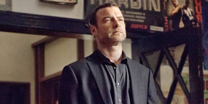 Liev Schreiber as Ray Donovan standing in a building and looking ahead in Ray Donovan.