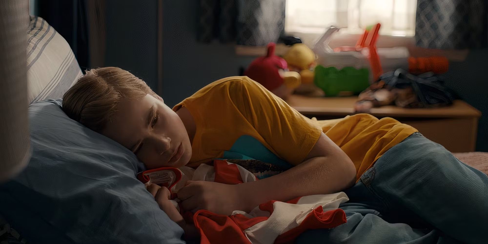 Austin (Diesel La Torraca) crying in bed holding a jersey his father gave him in Ginny & Georgia Season 3.