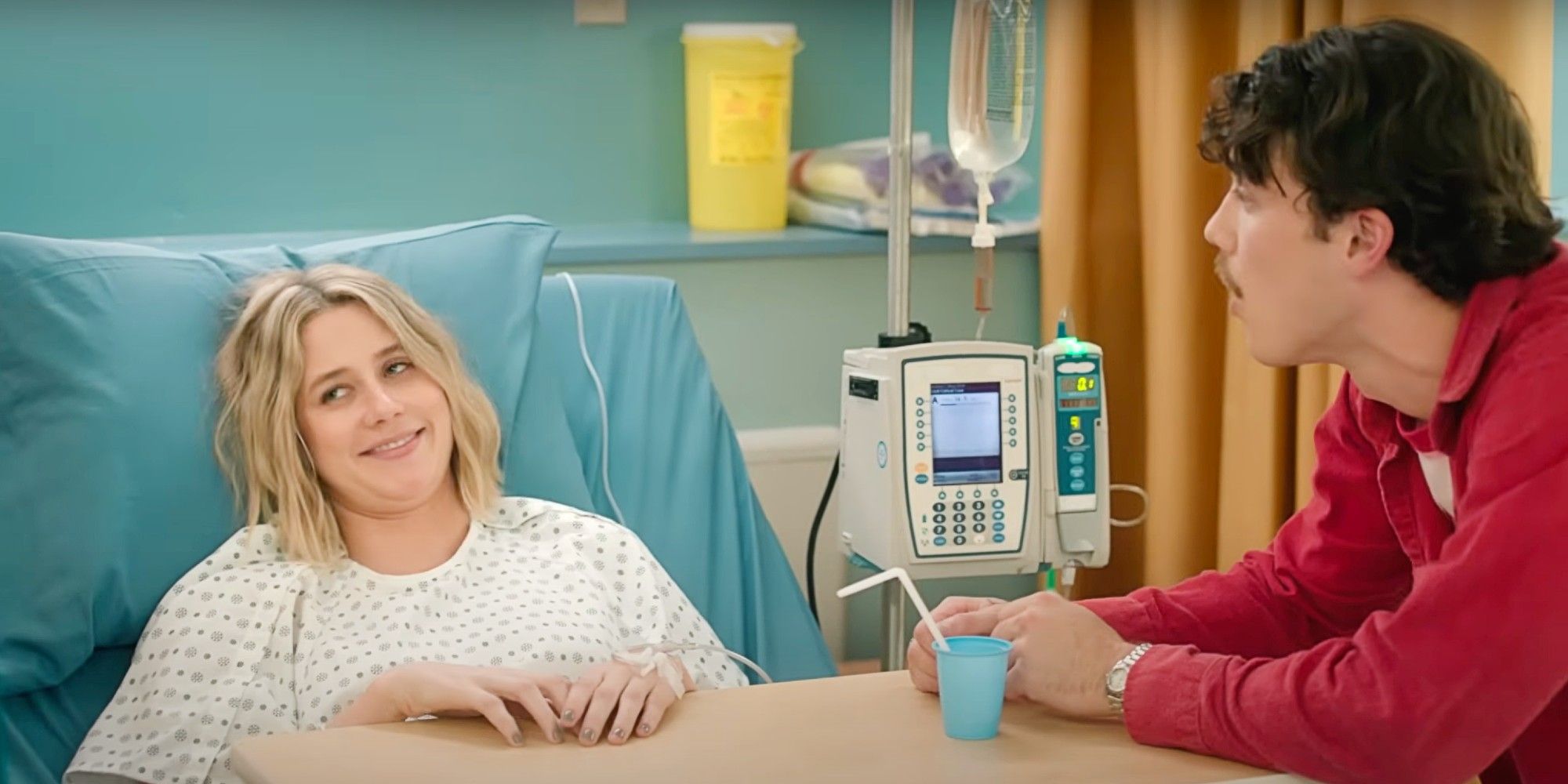 Billie high and laying in a hospital bed while Paul Baker stands by her bedside in Adults.