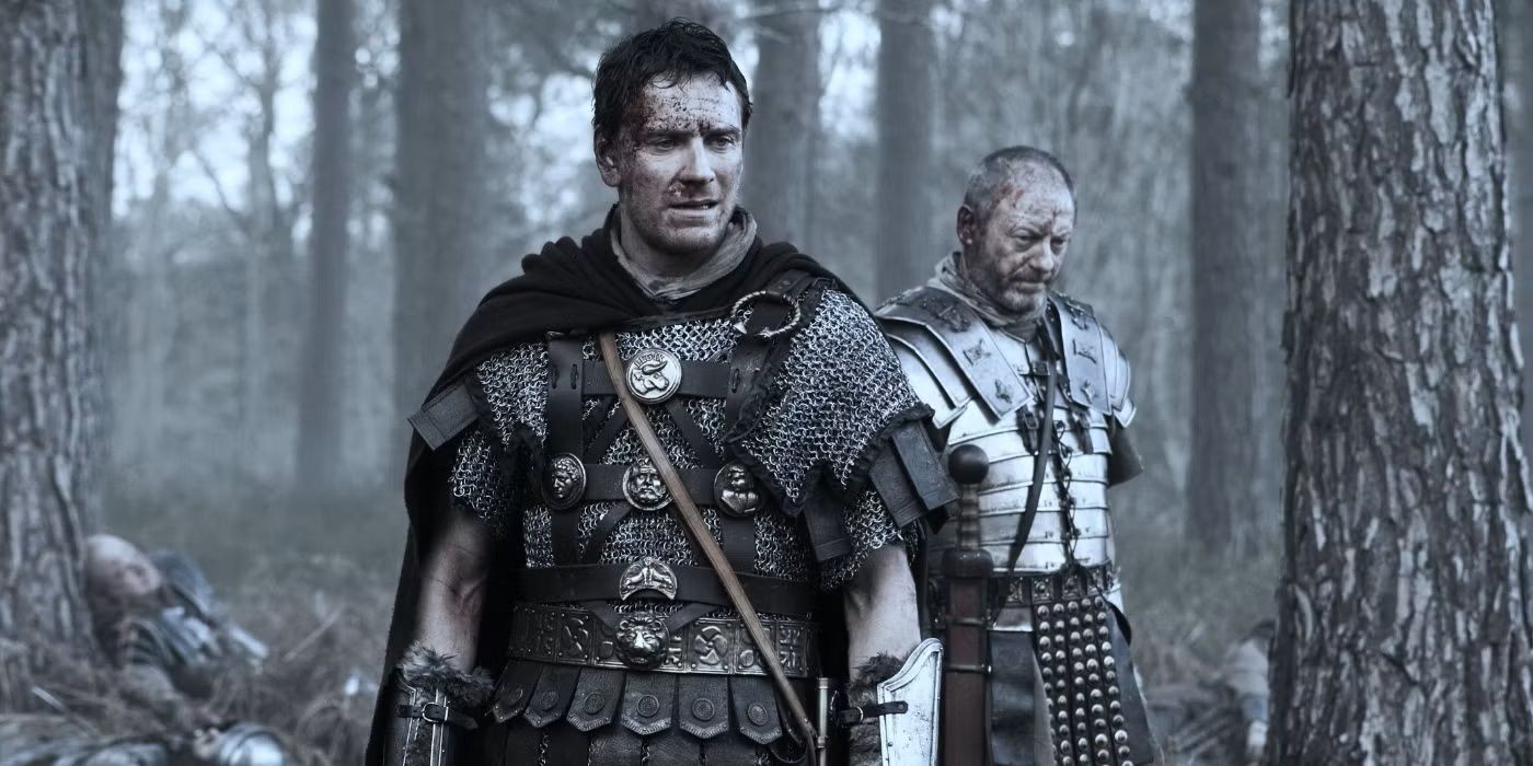 Michael Fassbender and Liam Cunningham in Roman armor stands in a forest