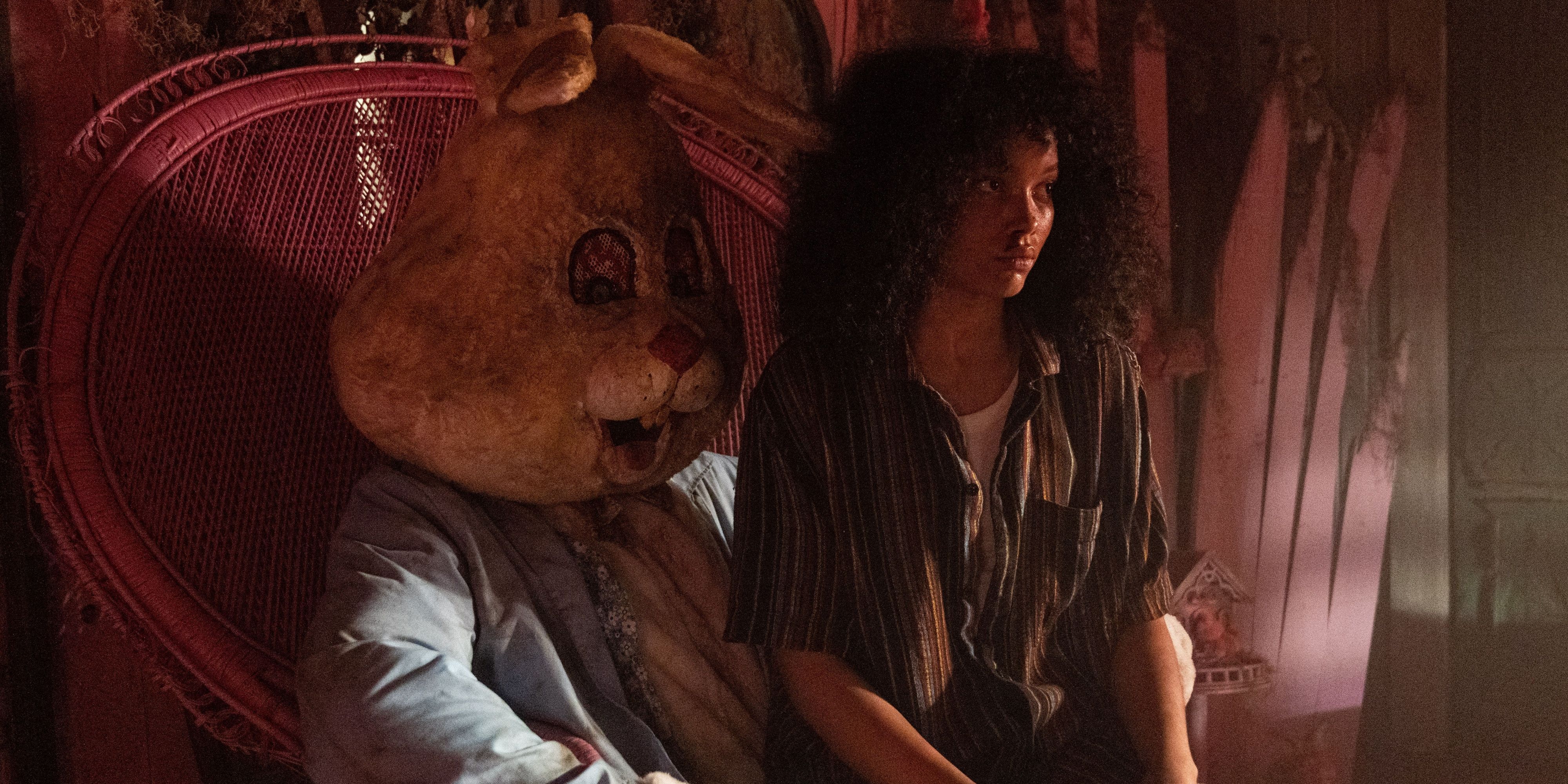 Actor Whitney Peak as Anna, looking dazed and sitting on the lap of a person in a rabbit costume in Eye For an Eye.