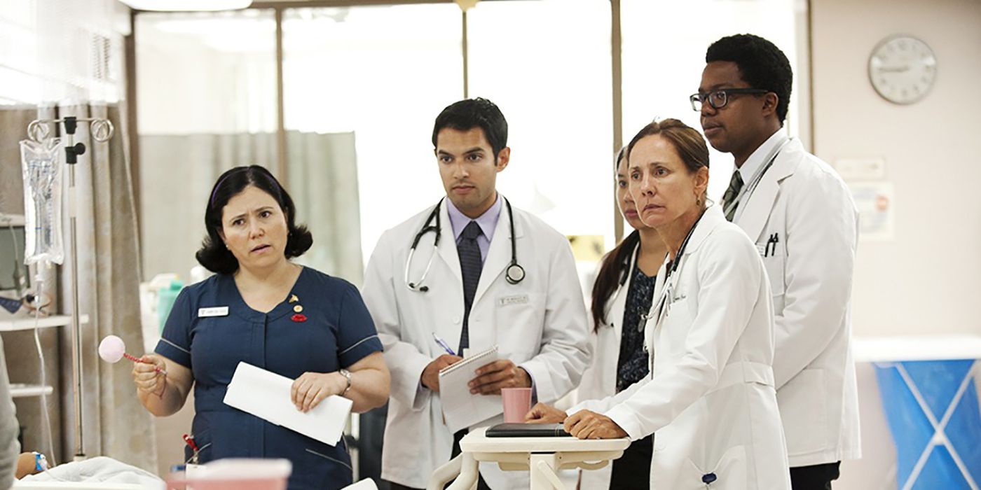 Um grupo de médicos em casacos brancos olhando para algo para se dar bem.