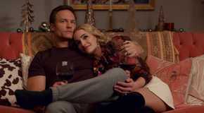 Georgia (Brianne Howey) and Paul (Scott Porter) cuddle on the couch in Ginny and Georgia.