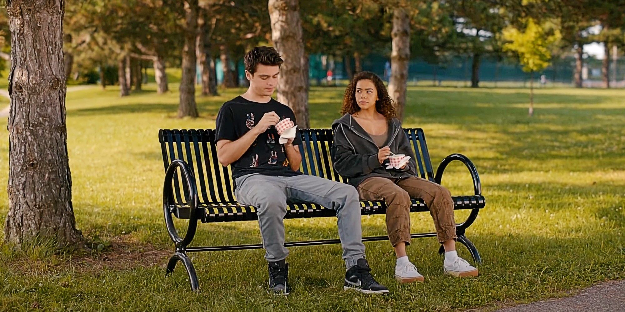 Marcus Baker and Ginny Miller eating ice cream on a park bench in Ginny and Georgia Season 3.
