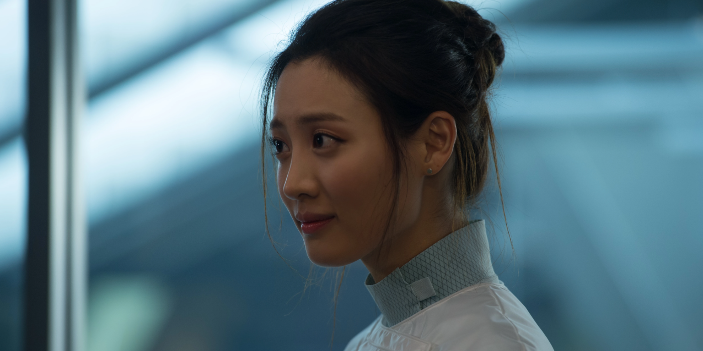 Helen, dressed in a medical suit, smiles slightly while looking off-screen in Avengers: Age of Ultron.