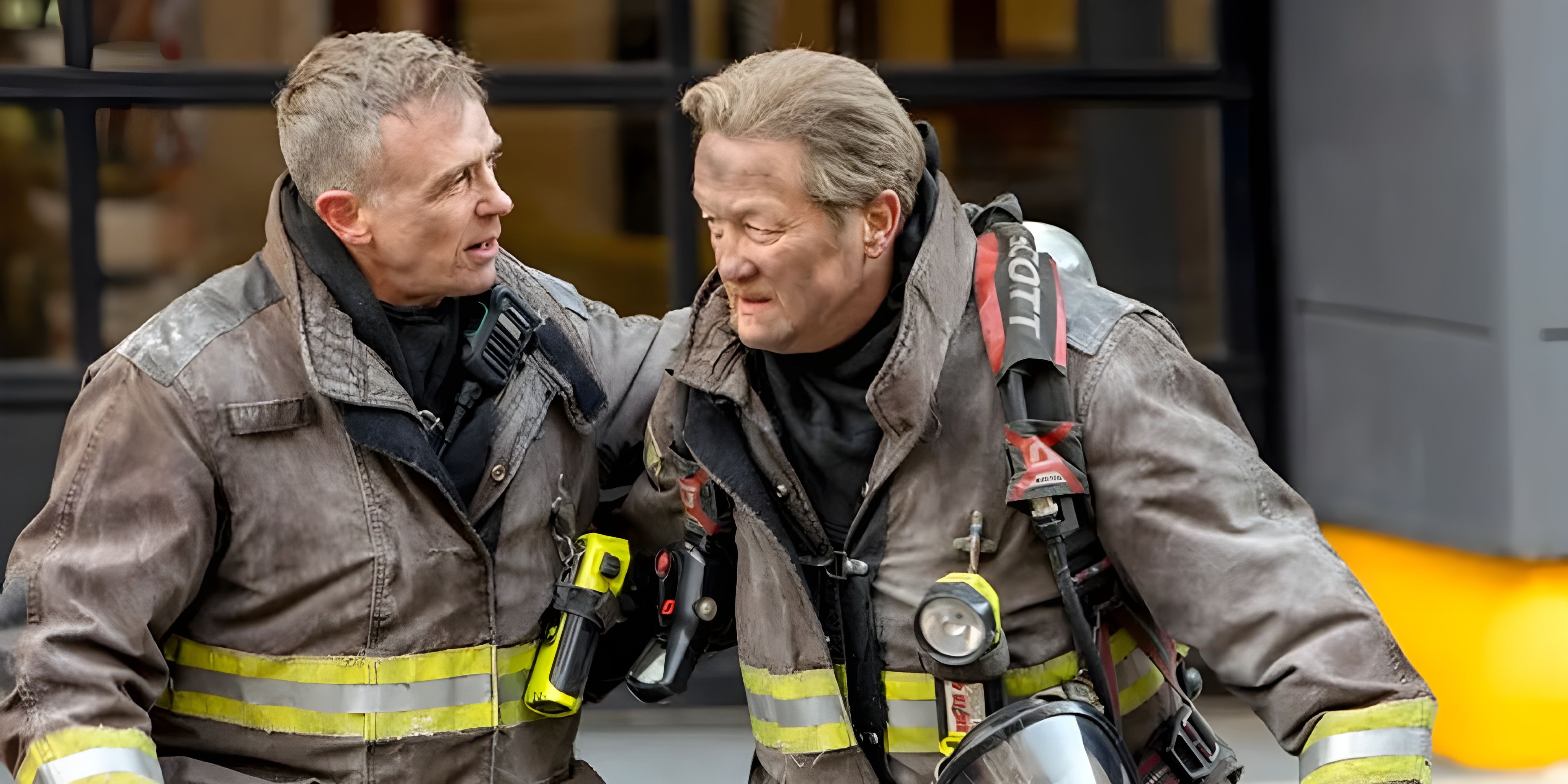Herrmann (David Eigenberg) and Mouch (Christian Stolte) standing together in fire gear on Chicago Fire.
