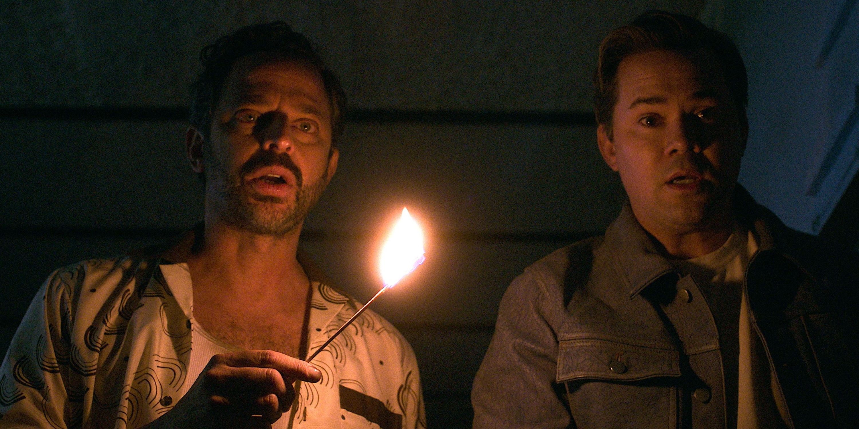 Dom and Cole, played by actors Nick Kroll and Andrew Rannells, stand in the dark with Dom holding a lit match in I Don't Understand You.