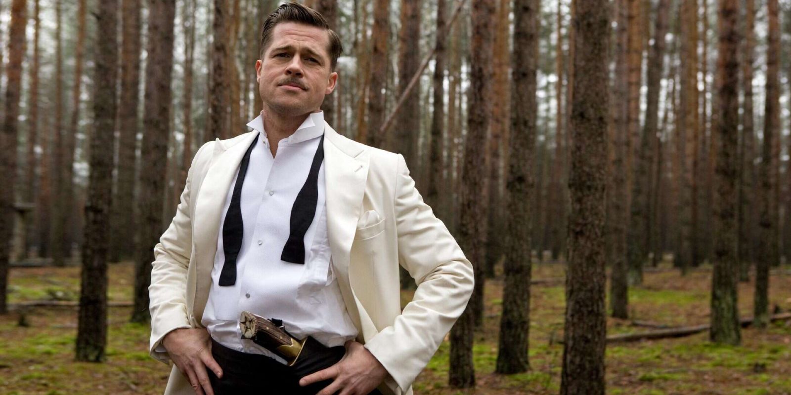 Brad Pitt, Aldo Raine olarak ormanda duran, Indlourious Basterds'de dağınık bir smokin içinde duruyor.