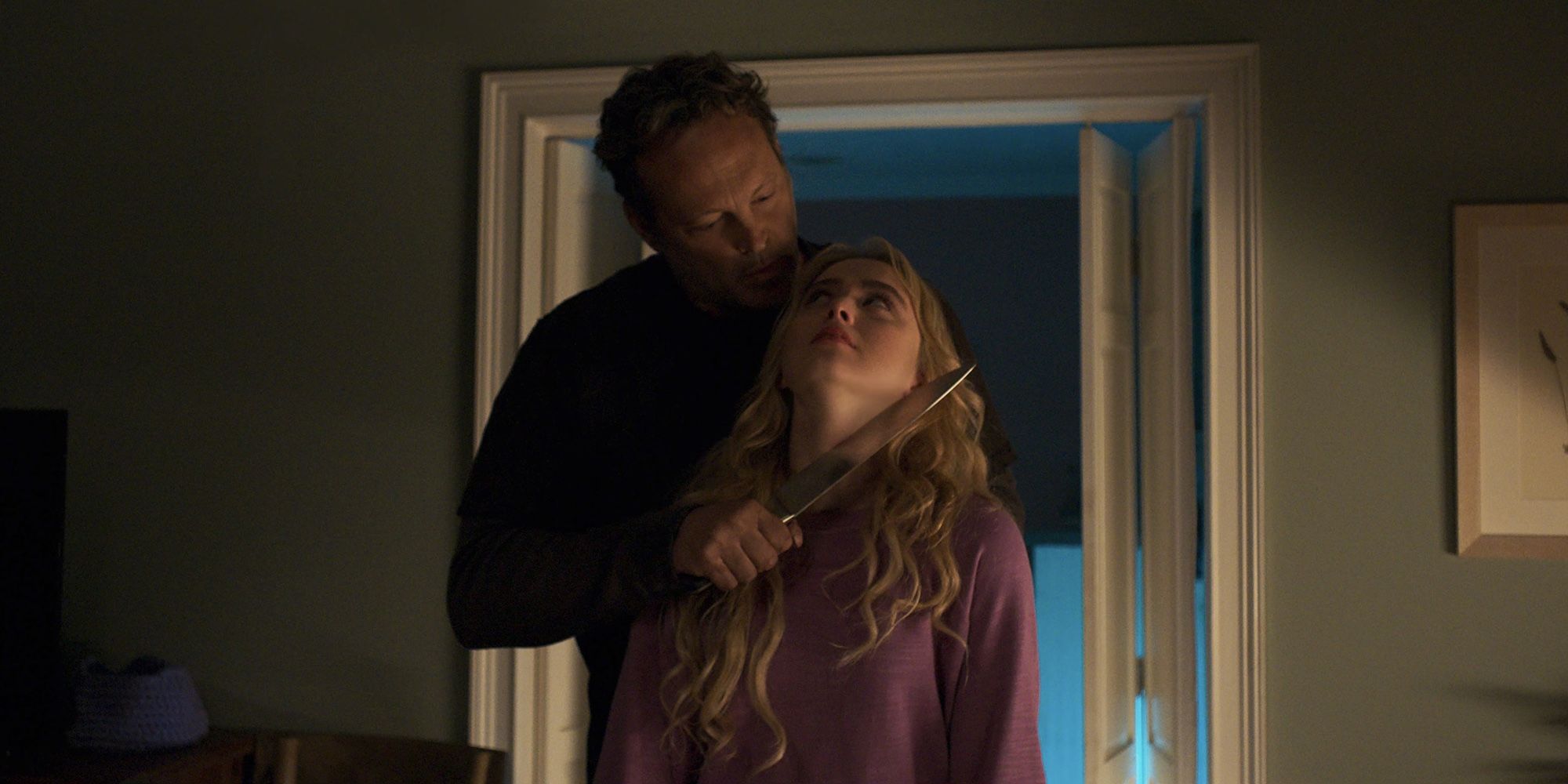 Vince Vaughn segurando uma faca grande na garganta de Kathryn Newton em Freaky