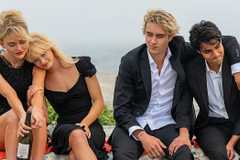 Cady, Mirren, and Johnny Sinclair sitting with Gat Patil after a funeral in We Were Liars.