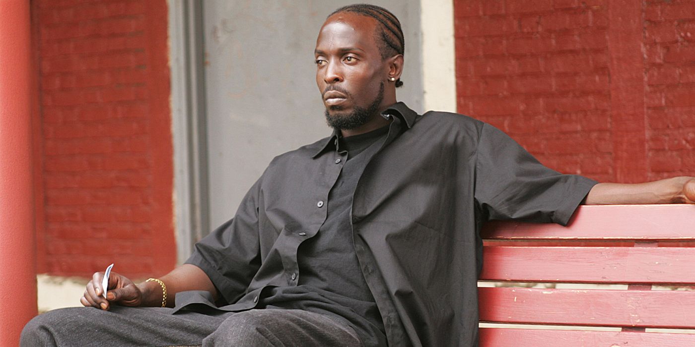 Michael K. Williams as Omar Little sitting on a bench and staring ahead in The Wire.