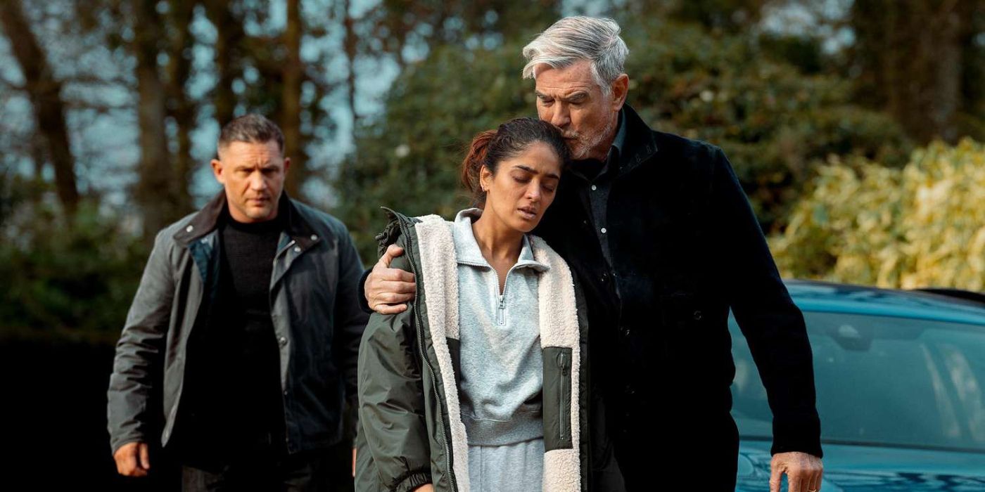 Conrad Harrigan (Pierce Brosnan) segurando Seraphina (Mandeep Dhillon) perto de Harry (Tom Hardy) atrás deles na Mobland