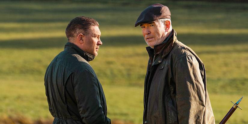 Tom Hardy as Harry Da Souza and Pierce Brosnan as Conrad Harrigan talk on a green field in MobLand