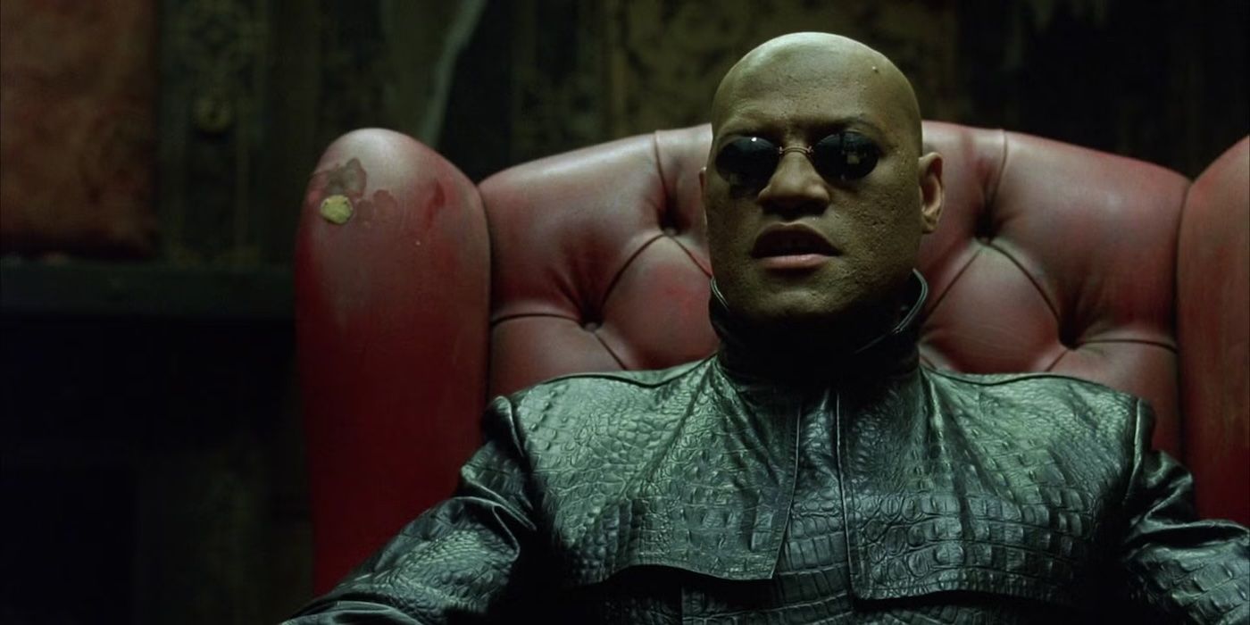Laurence Fishburne as Morpheus sitting in an old chair and wearing round sunglasses in The Matrix.