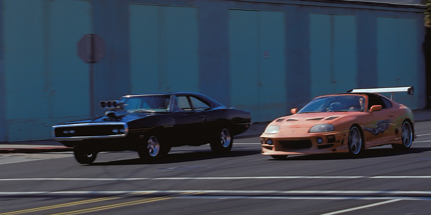 A black car and an orange car race side by side in The Fast and the Furious, 2001.