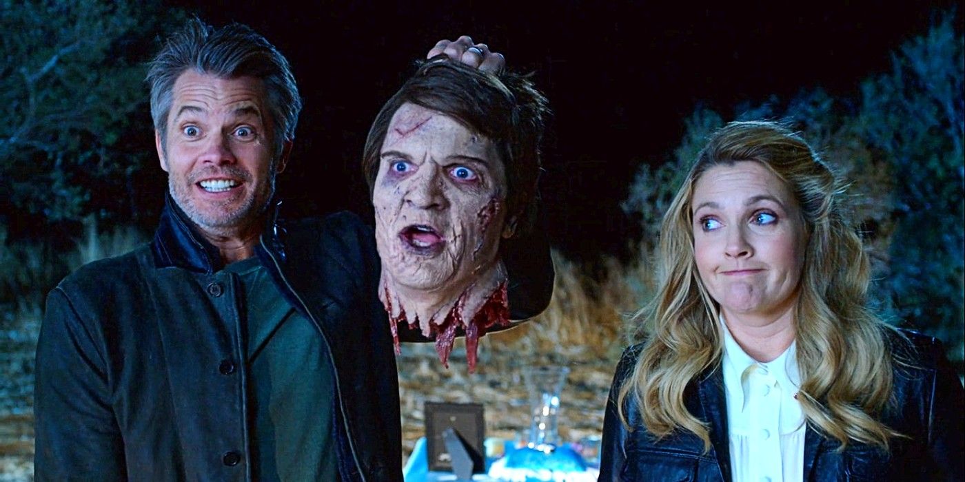 Timothy Olyphant as Joel Hammond holding the disembodied head of Nathan Fillion as Gary, beside Drew Barrymore as Sheila Hammond in Santa Clarita Diet.