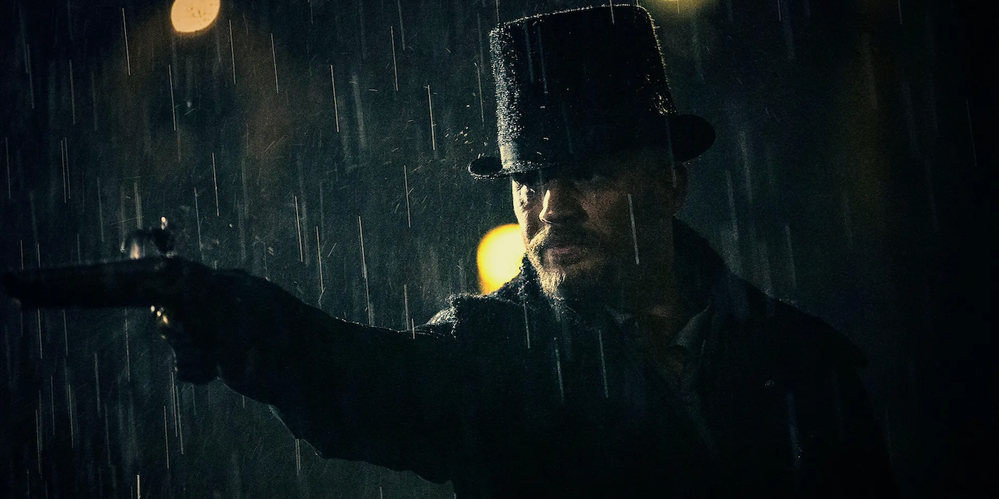 James Delaney, de Tom Hardy, segura uma pistola na chuva no tabu.