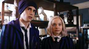 Ajax (Georgie Farmer) and Enid (Emma Myers) stand inside a taxidermy shop in Season 1 of Wednesday.