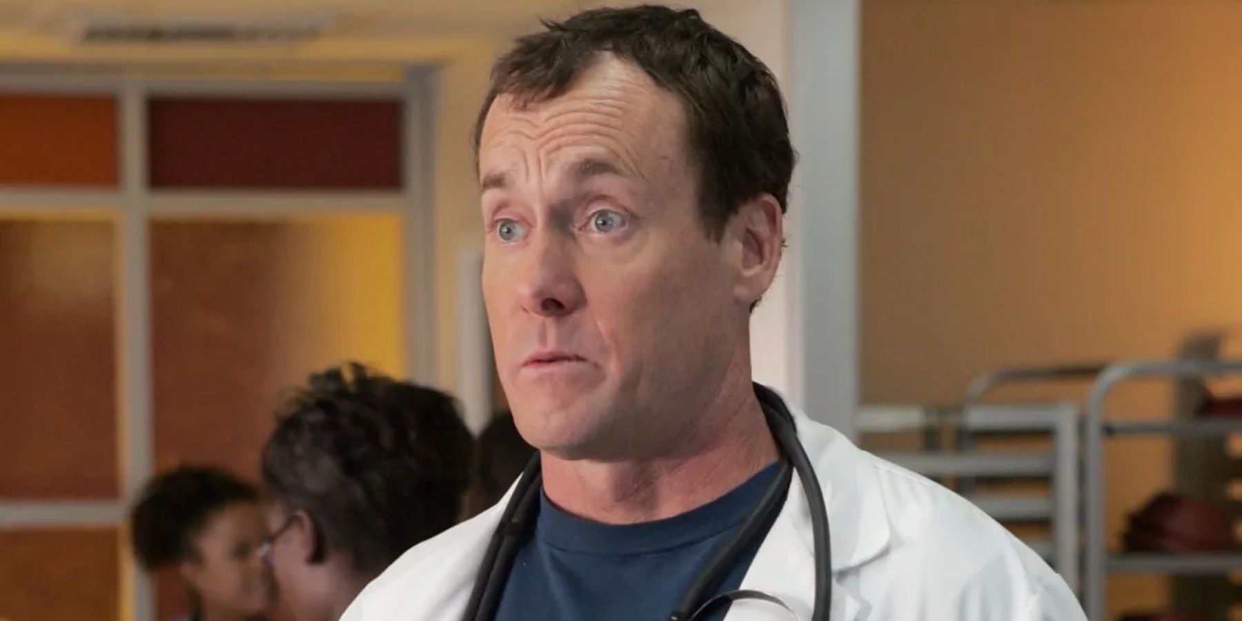 John C. McGinley as Dr. Perry Cox in a doctor's coat and stethoscope looking baffled in Scrubs.