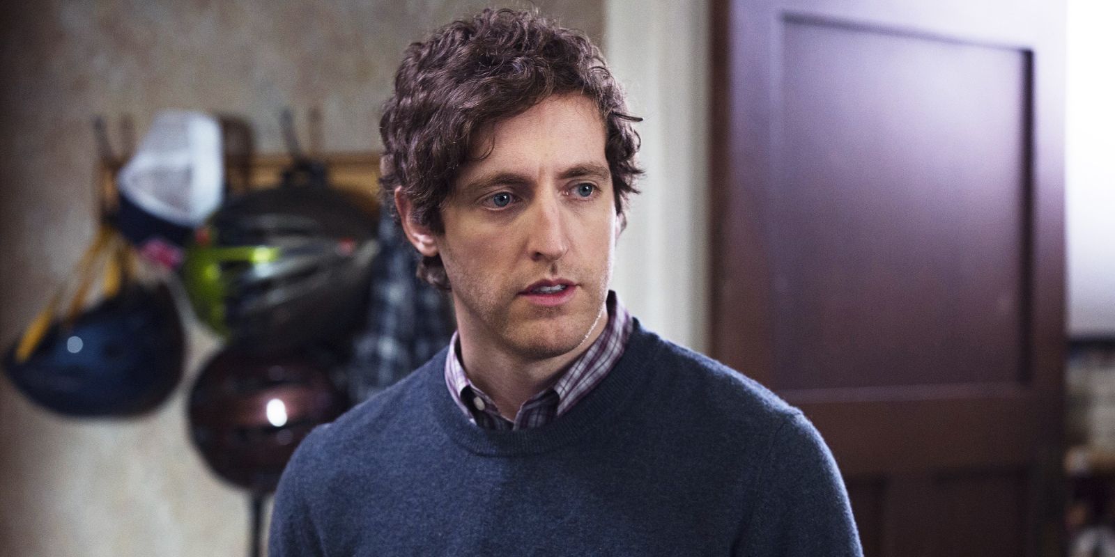 Richard standing in a room and looking to the side with bike helmets in the background in Silicon Valley.