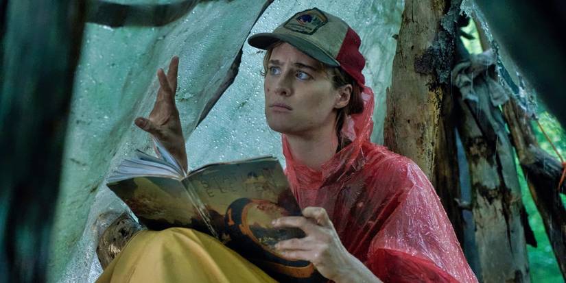 MacKenzie Davis reading the Station Eleven comic book in a rainy tent in Station Eleven.