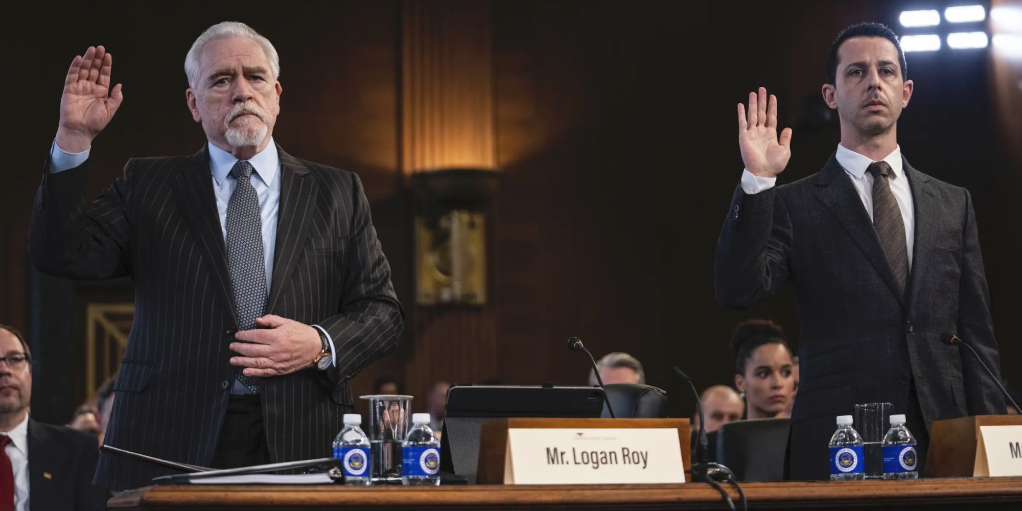 Two of the cast members have their hands raised in a courtroom in the Succession episode DC.