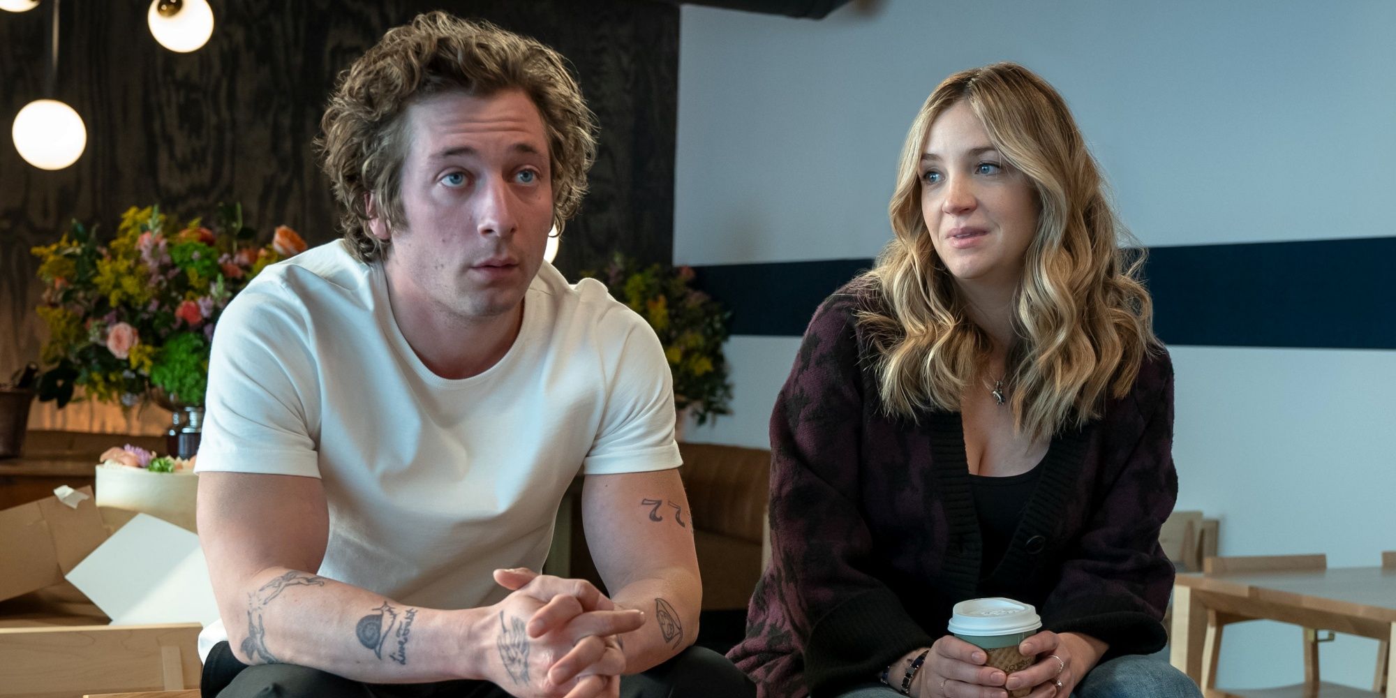 Abby Elliott como açúcar sentado no restaurante vazio ao lado de Jeremy Allen White como Carmy no Bear Season 2