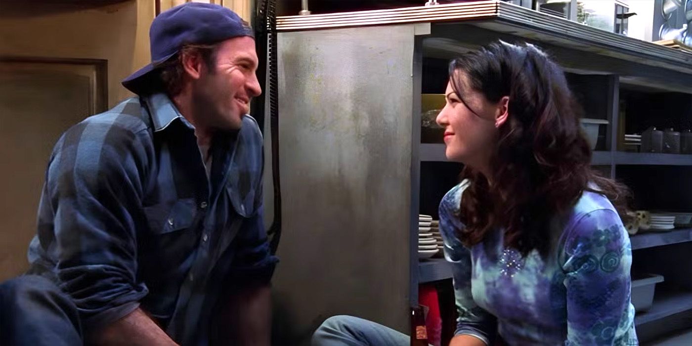 Lorelai (Lauren Graham) and Luke (Scott Patterson) smiling at each other and sitting on the floor in the Gilmore Girls episode "That Damn Donna Reed"
