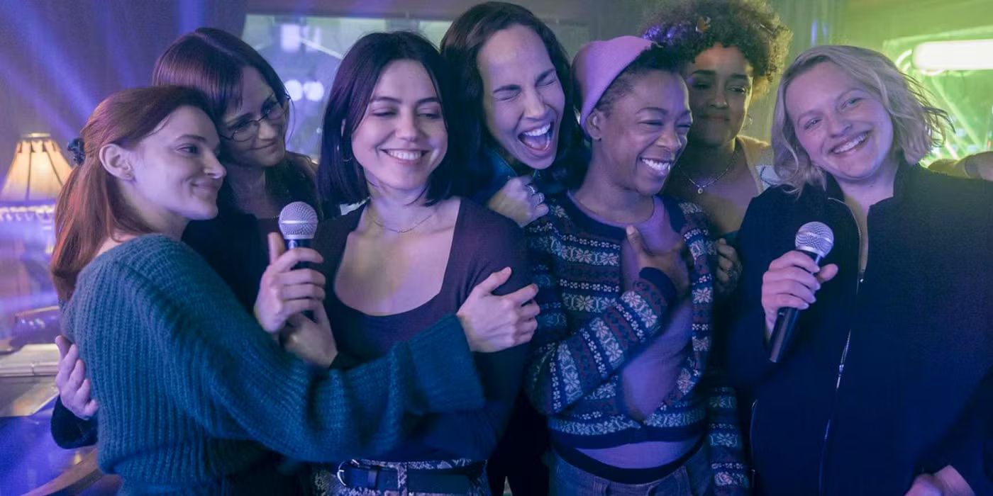 Elisabeth Moss, Samira Wiley, Madeline Brewer e outros cantando karaokê no flashback da história da Handmaid