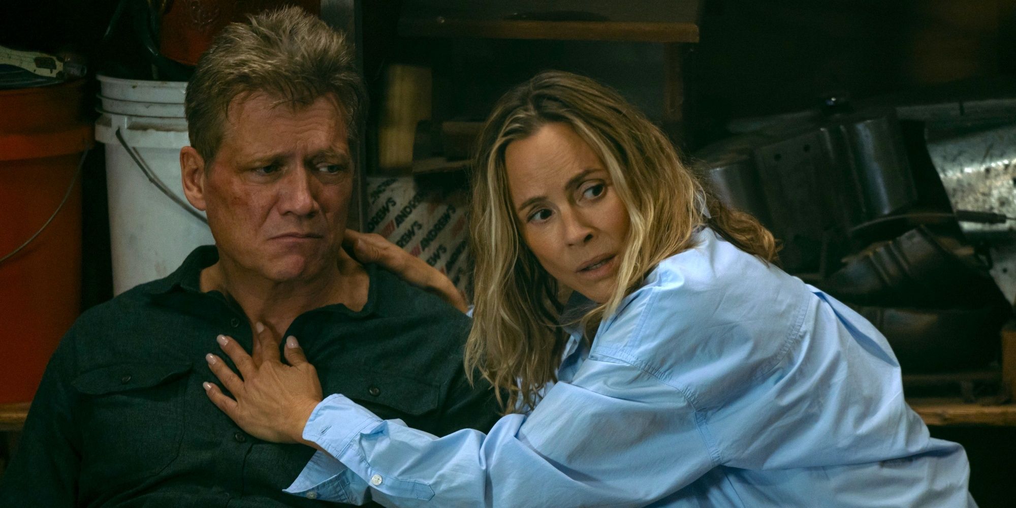 Holt McCallany as Harlan on the ground with Maria Bello as Belle looking concerned in The Watefront