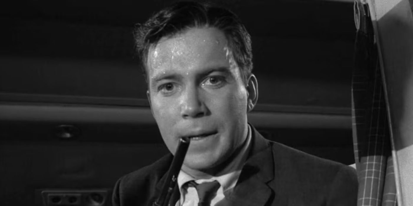 William Shatner as Robert in a nervous sweat holding a gun in Twilight Zone's Nightmare at 20,000 Feet.
