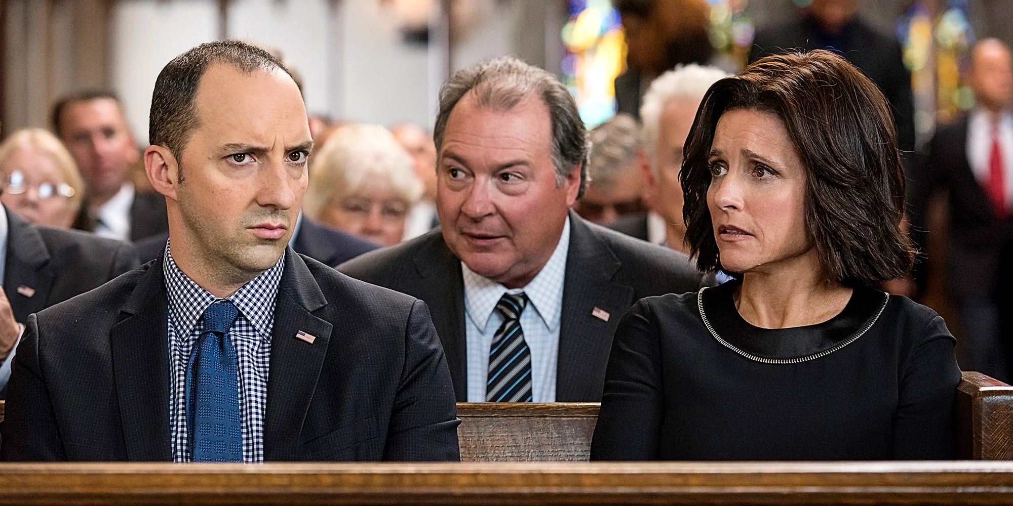 Selina Meyer, Gary Walsh, and Ben Cafferty sitting in the church pugh at Selina's mother's funeral in Veep.