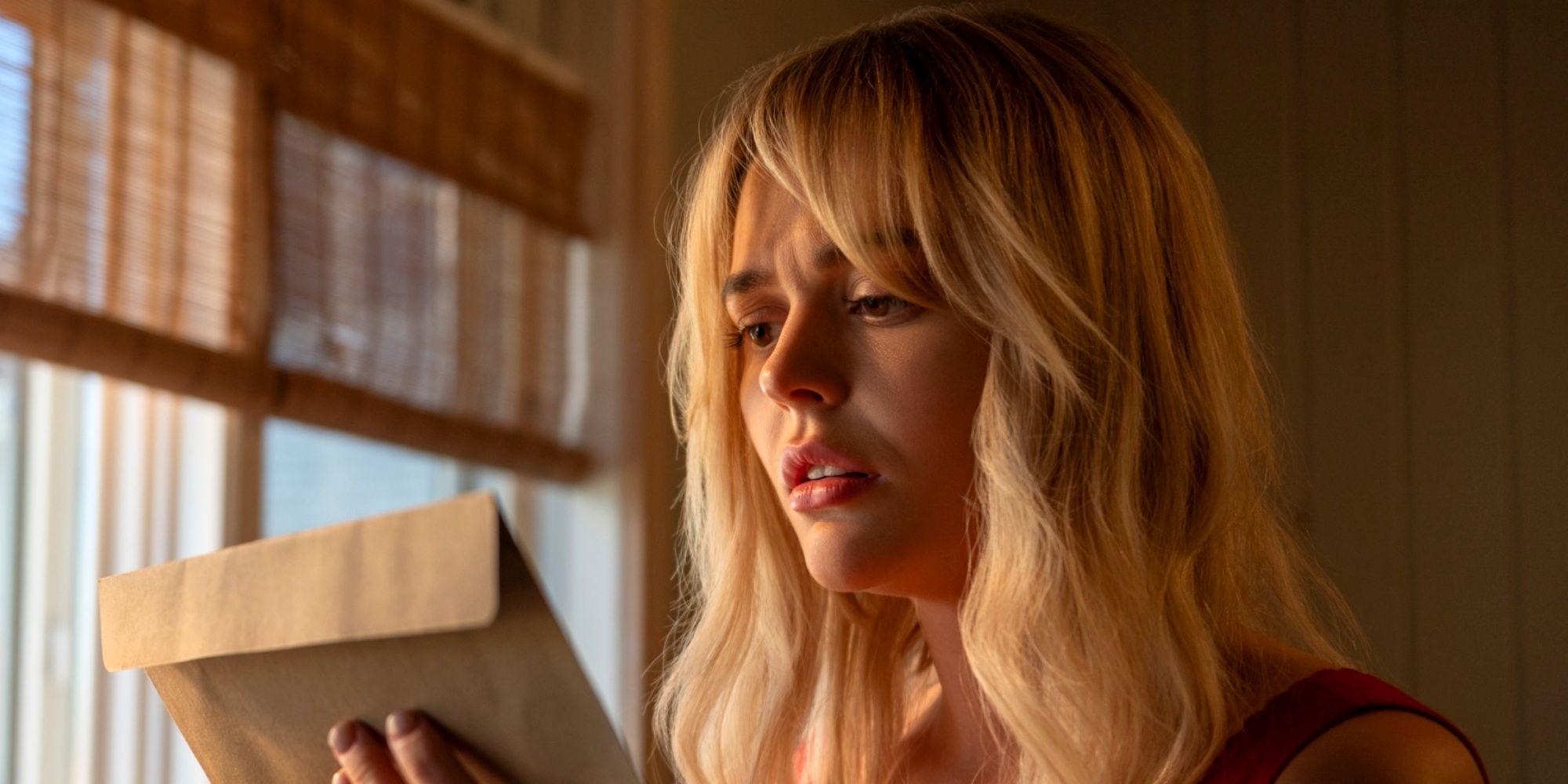 Emily Alyn Lind as Cadence Sinclair Eastman looking at an envelope with concern in We Were Liars.