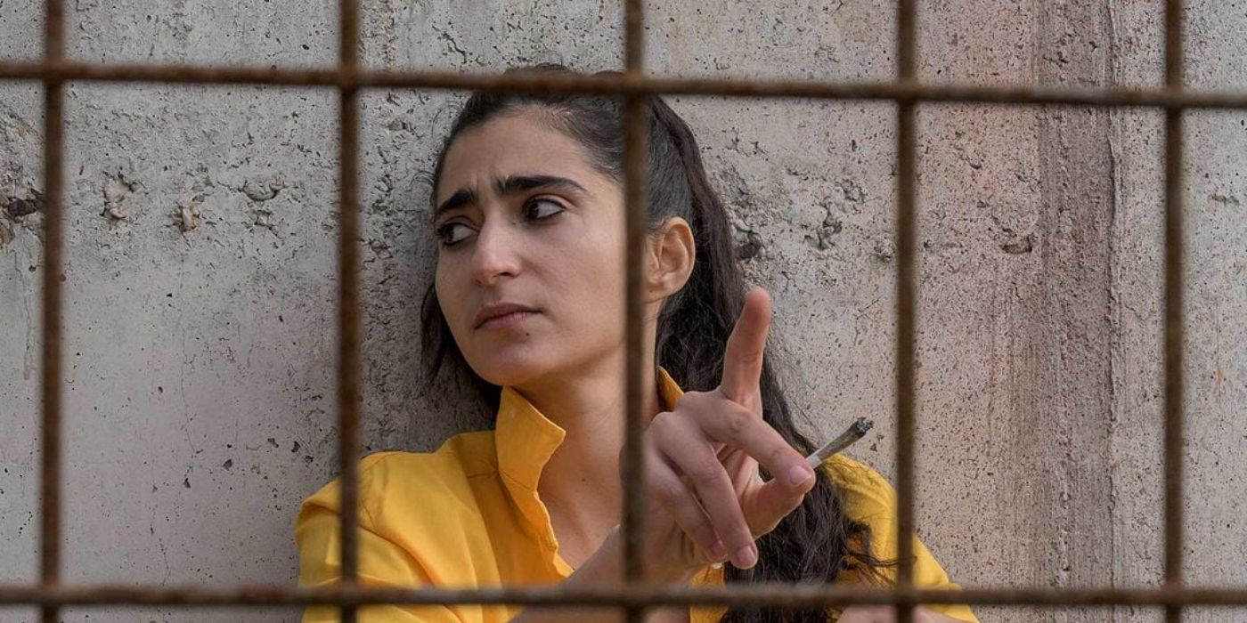Alba Flores as Saray smoking a cigarette in a yellow jumpsuit in Locked Up