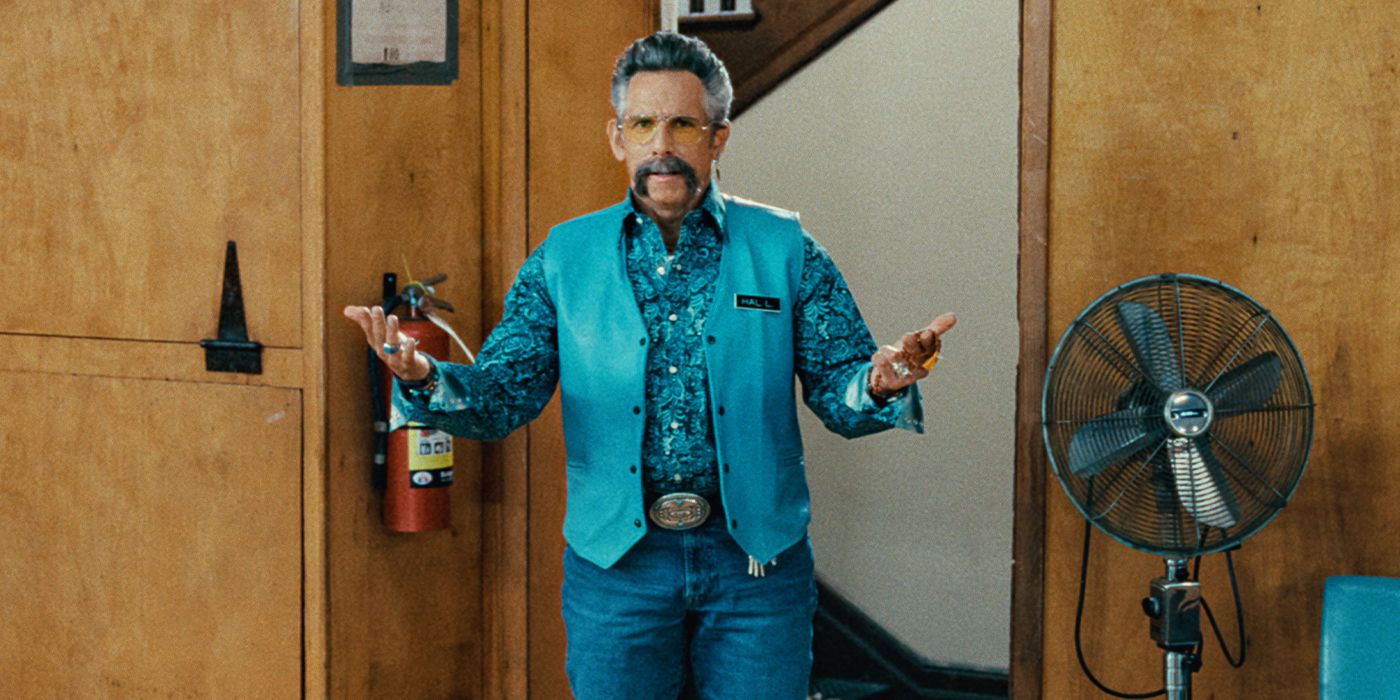 Hal L. Zilā Paisley kreklā un zilā veste ar roku, kas pagarināta Happy Gilmore 2.