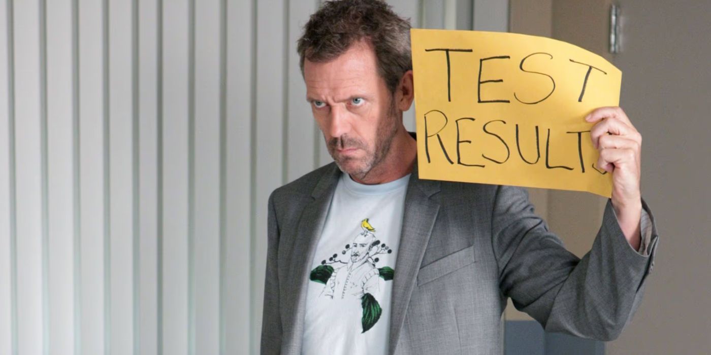 Hugh Laurie holding a sign that says Test Result in House M.D. Season 7, Episode 2, "Selfish."