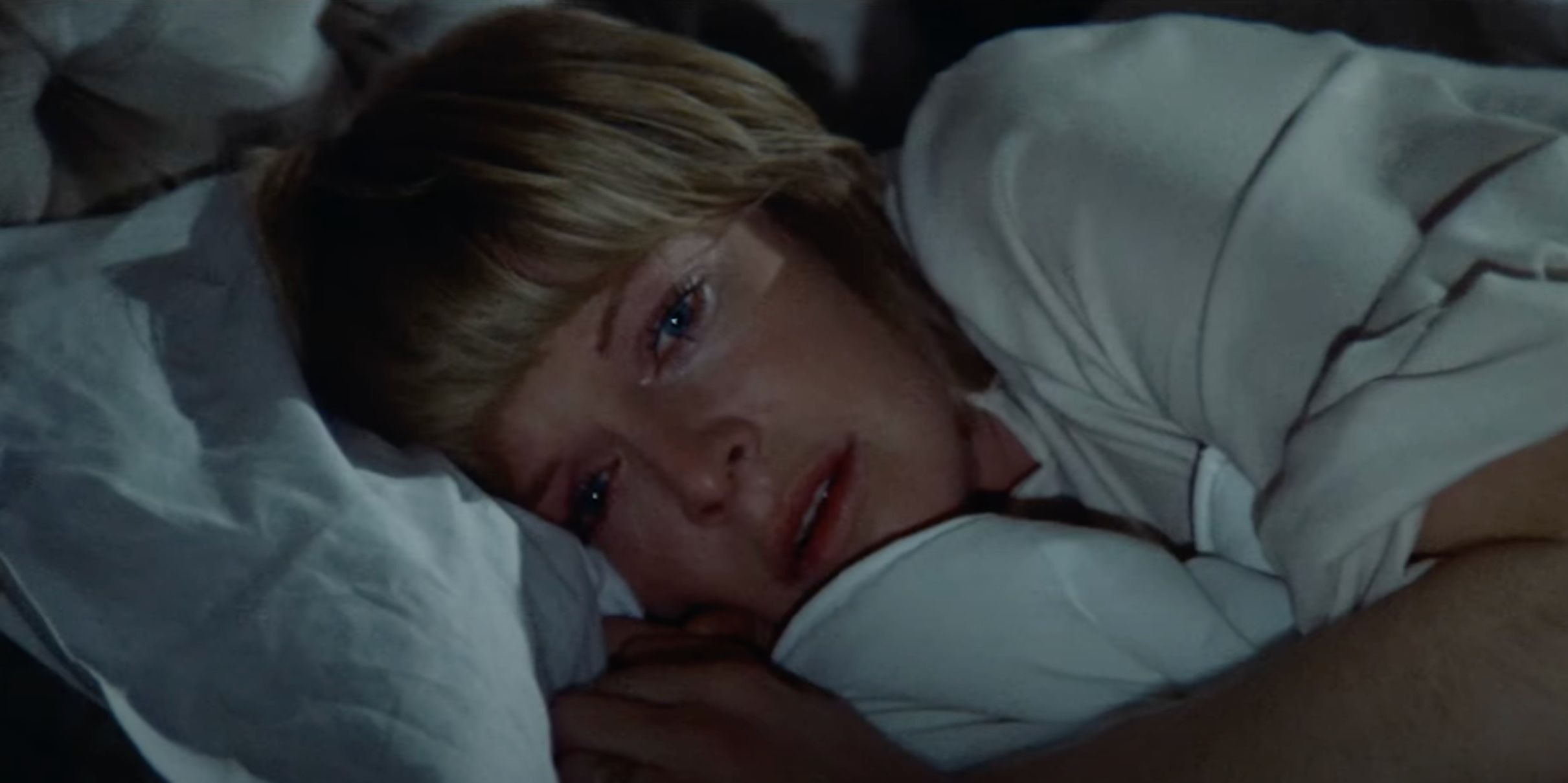 Susannah York enquanto Cathryn está na cama, segurando os lençóis e parecendo chateado em imagens