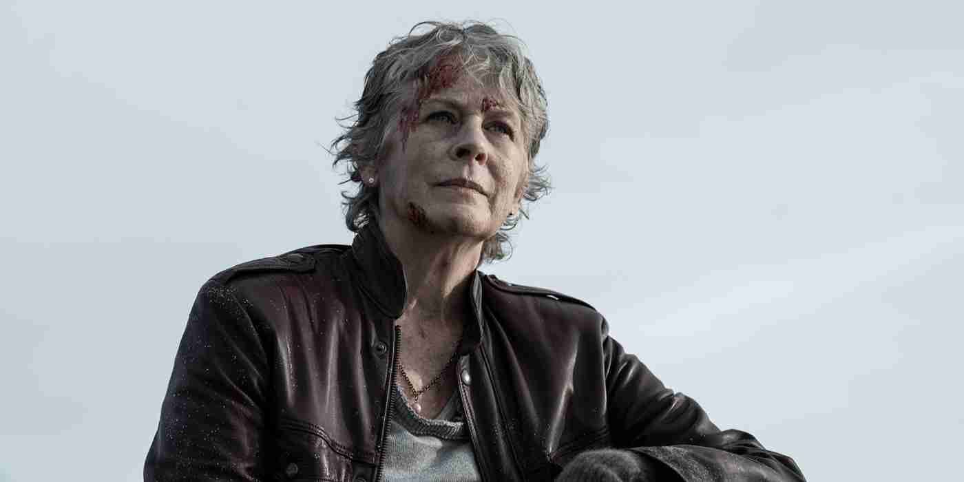 Melissa McBride as Carol wears a leather jacket and looks off camera