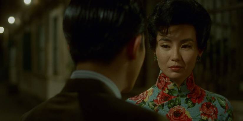 Maggie Cheung portant une robe fleurie bleue en regardant Tony Leung qui fait face à la caméra dans l'ambiance pour l'amour 