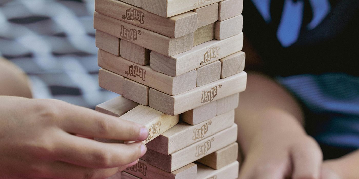 Jenga oyunundan bir bloğu çeken birinin yakın çekimi.