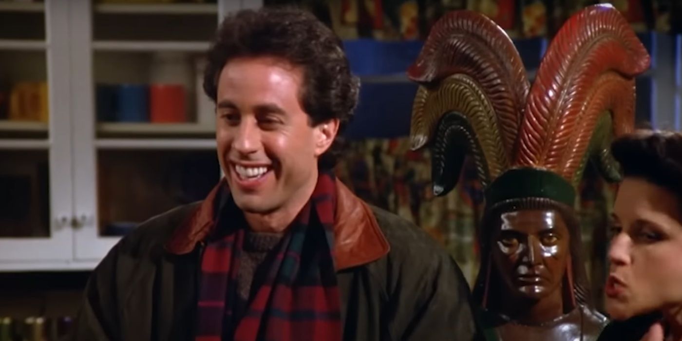 Jerry Seinfeld smiling in front of a Native American statue in 'Seinfeld' Season 5, Episode 10.