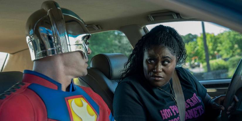 John Cena and Danielle Brooks sitting in car as Christopher Smith and Leota Adebayo in 'Peacemaker' Season 2.
