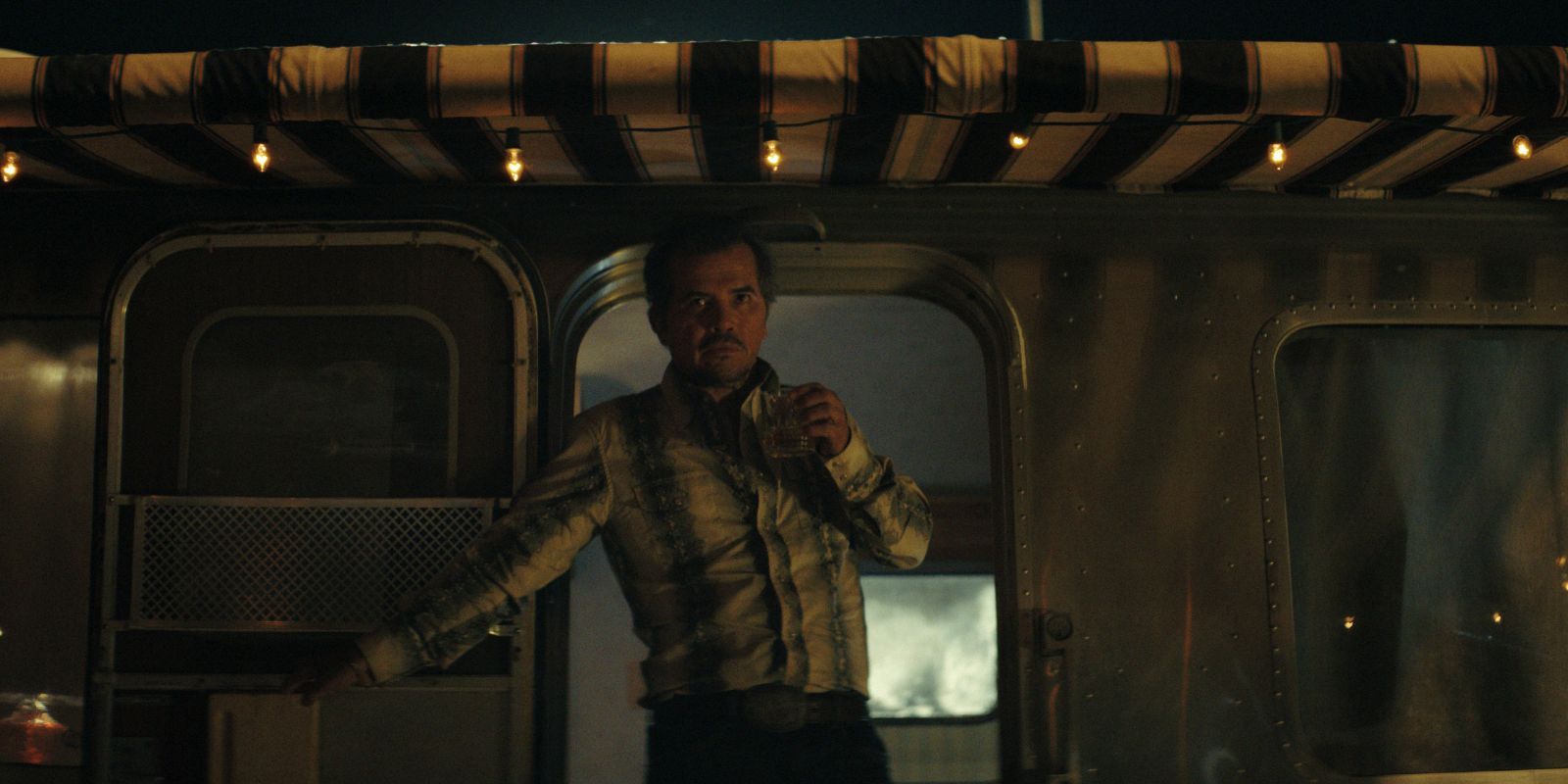 John Leguizamo saindo de um trailer em fumaça